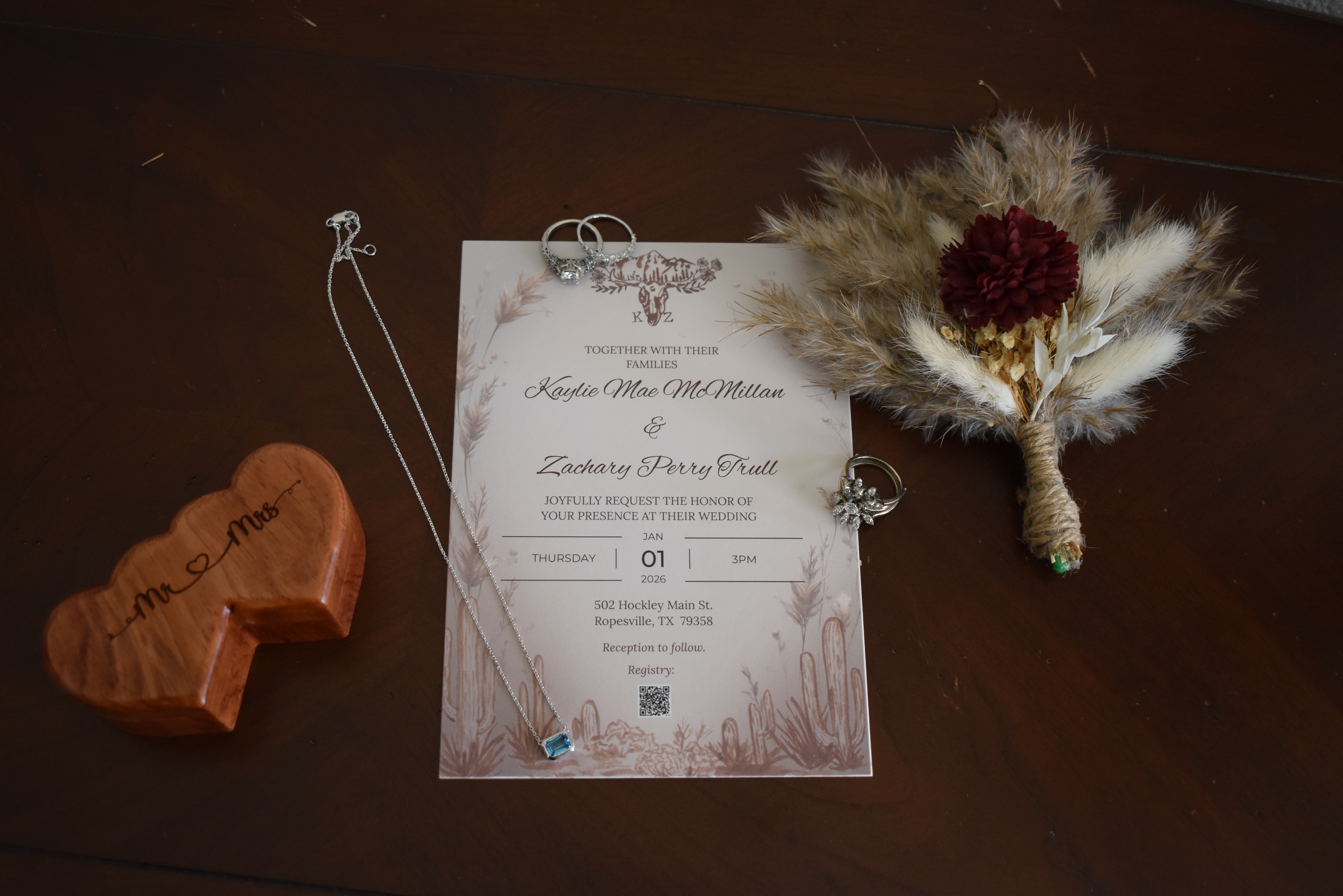 Wedding invitation flatlay with boutonnière and rings